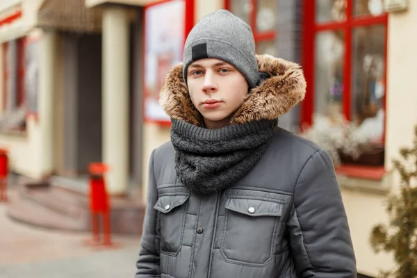 Jovem bonito em uma jaqueta de inverno na moda com um lenço um — Fotografia de Stock