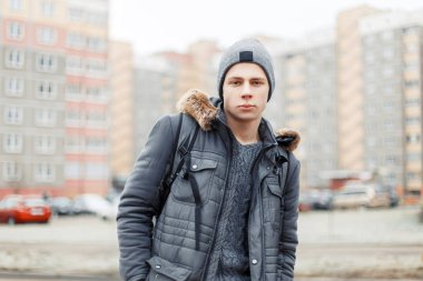 yakışıklı genç bir şapka ve çanta traveli ile kış ceket