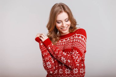 Studio gri arka plan üzerinde süsleme ile vintage kırmızı kazaklı genç kız mutlu moda