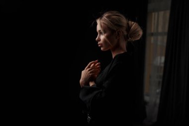 Karanlık bir odada poz şık siyah giysili güzel genç kadın