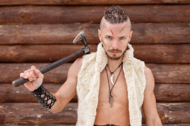 Viking adam savaşçı bir hayvan bir ahşap duvar yakınındaki deri bir balta ile
