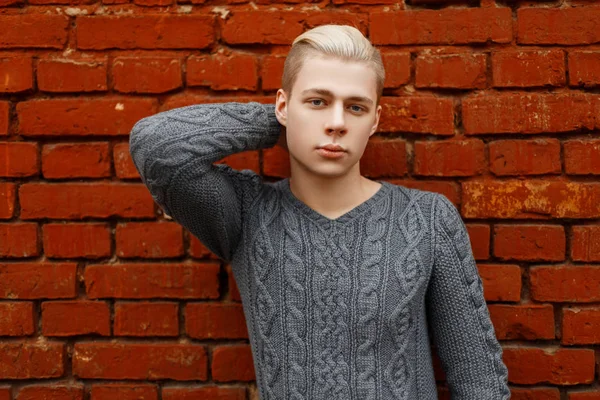 Portrait of a young guy with a trendy haircut in a knitted sweat — Stock Photo, Image