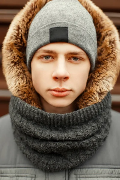 Retrato de inverno de um jovem em uma jaqueta de moda de inverno com um — Fotografia de Stock