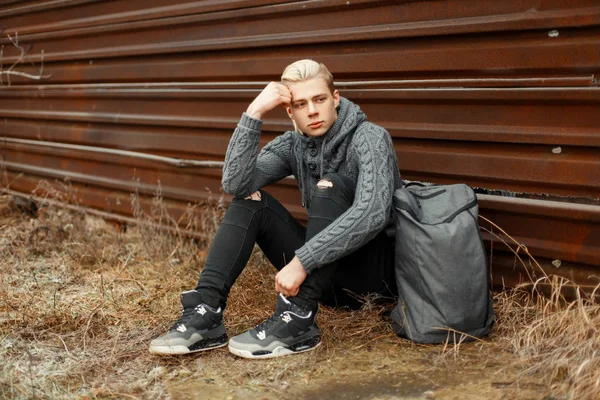 Knappe jonge man in een hippe gebreide trui met stijlvolle snea — Stockfoto