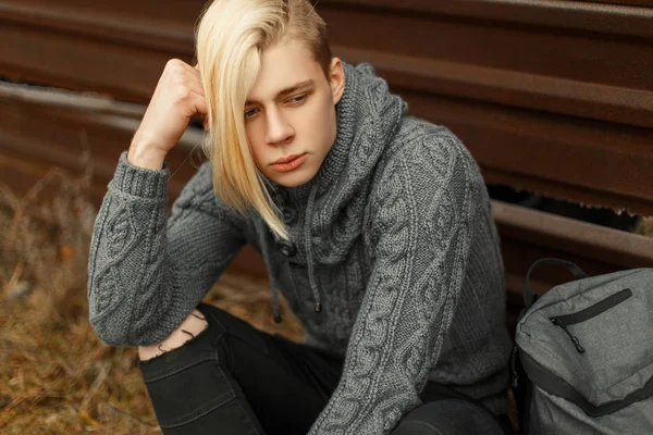 Mode beau jeune homme avec une coiffure dans un pull tricoté — Photo