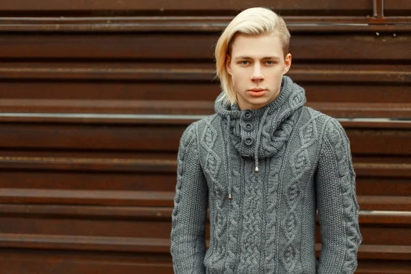 A divat a kötött pulóvert, csinos, fiatal férfi áll közel a rozsda — Stock Fotó