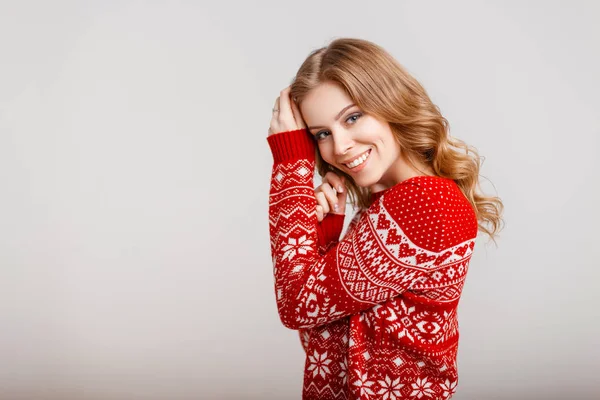 Hermosa joven en un suéter vintage rojo sobre un fondo gris —  Fotos de Stock