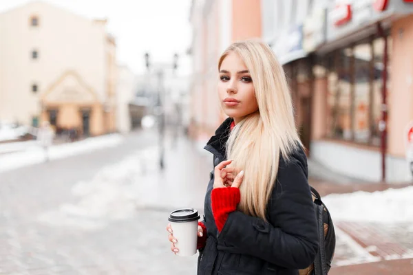 Стильная модель женщина с кофе в моде зимнее пальто с мешком ходьба по городу — стоковое фото