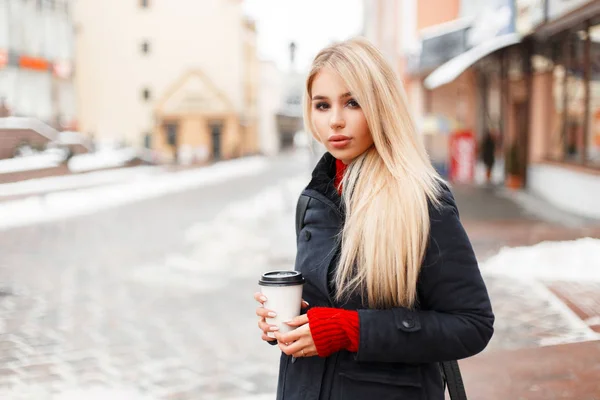 Menina modelo muito glamourosa com café em um casaco vintage de inverno de moda com um saco andando na cidade — Fotografia de Stock