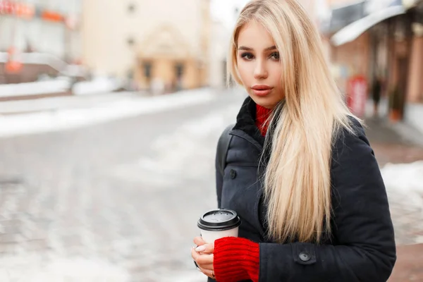 Jovem mulher de moda bonita com café em um casaco vintage na moda está viajando na cidade — Fotografia de Stock