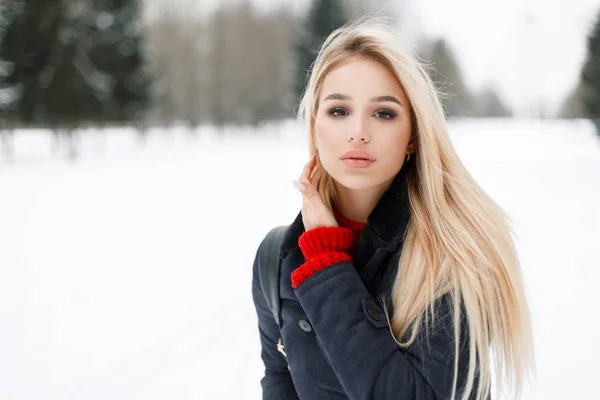 Όμορφη νεαρή ξανθιά γυναίκα σε μοντέρνα χειμερινά παλτό περπάτημα σε εξωτερικούς χώρους μιας χειμερινής μέρας — Φωτογραφία Αρχείου