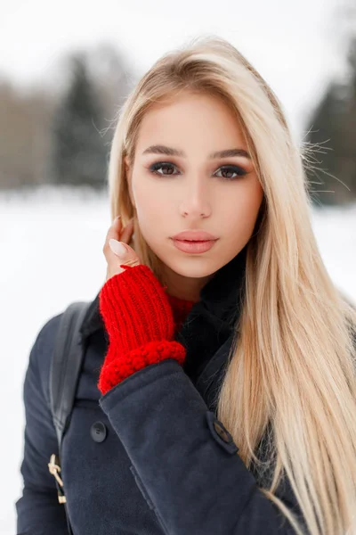Piękna stylowa dziewczyna model w stylowy elegancki płaszcz z torbą na zimowy śnieżny dzień w parku — Zdjęcie stockowe