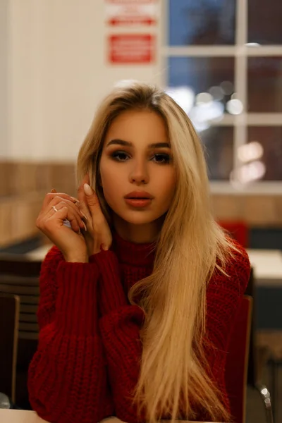 Portrait d'une belle jeune femme en pull rouge dans un café la nuit — Photo