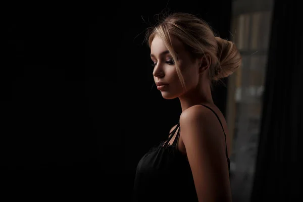 Sexy menina bonita jovem em roupas pretas em um quarto escuro — Fotografia de Stock