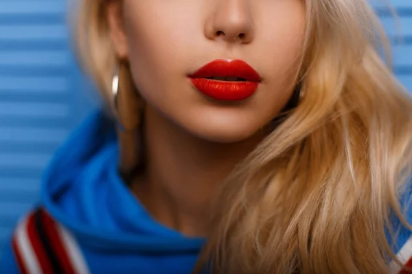 Primeros planos hermosos labios femeninos con lápiz labial rojo sobre fondo azul —  Fotos de Stock