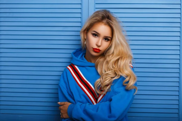 Hermosa mujer joven en ropa azul de moda cerca de una pared de madera —  Fotos de Stock