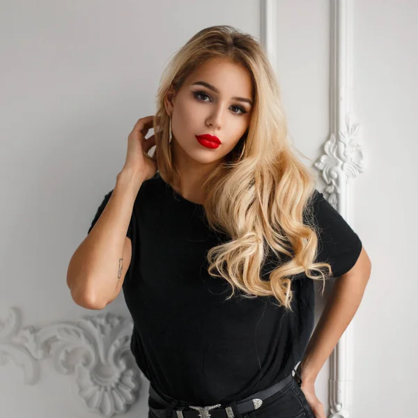 Dość młoda kobieta elegancka w modny czarny T-shirt w pobliżu biała ściana — Zdjęcie stockowe