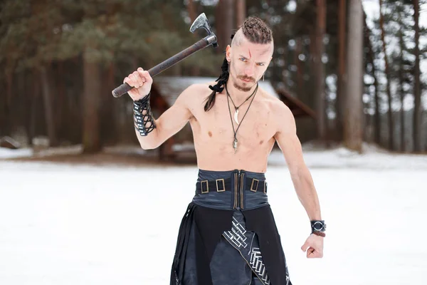 Guerreiro viking com um machado na floresta em um dia de inverno — Fotografia de Stock