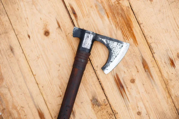 Battle ax of the Vikings lies on a wooden shield — Stock Photo, Image