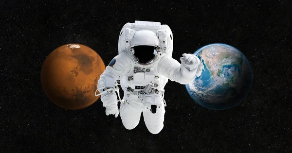 宇航员正前往火星上的一个新家。宇航员在开阔的空间, 在地球和火星的背景下。未来旅行的概念 — 图库照片