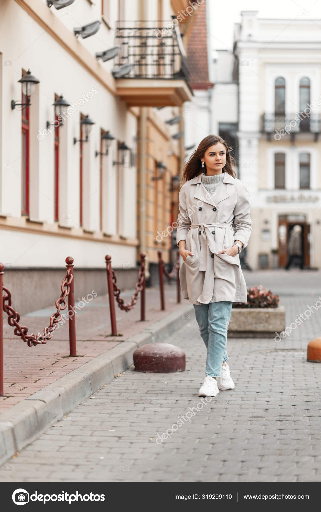 Mujer joven europea moderna en ropa de primavera de moda en zapatillas de deporte elegantes blancas