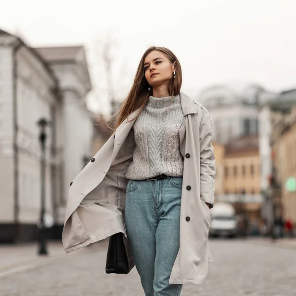 유럽 출신예쁜 갈색 머리의 젊은 여자가 낡은 빈티지 스웨터를 입고 가죽 가방을 들고 시내를 걷고 있다. 매력적 인 여자 모델 이 거리를 여행 한다. — 스톡 사진