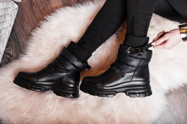 Stüdyoda şık, siyah kotlu, deri ayakkabılı genç bir kadının bacaklarının üstünde. Yeni moda modern gençlik sezonluk botları koleksiyonu. Mevsimlik ayakkabılar. Sıradan moda..