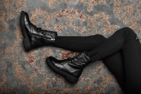 Вид сверху на ноги молодой женщины в винтажных кожаных туфлях в стильных черных джинсах в комнате. Модная современная молодежь новая коллекция сезонных сапог. Осенне-зимняя обувь. Случайный стиль . — стоковое фото