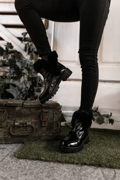 Detailní záběr módních černých zimních kožených teplých bot s kožešinou na ženských nohou. Sezónní nová stylová kolekce dámských teplých bot. Obuv pro mládež. — Stock fotografie