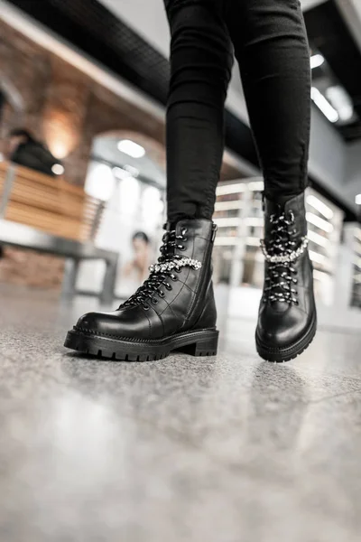 Seizoensgebonden collectie dameslaarzen. Stijlvolle jonge vrouw in modieuze lente-herfst zwart lederen lace-up schoenen in trendy jeans wandelingen op de winkel. Winkelen. Close-up. — Stockfoto