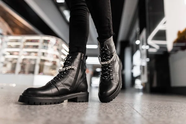 Mladá trendy žena v černých stylových džínách v módních kožených krajkových botách stojí v obchoďáku. Módní kolekce dámských podzimních bot s lesklými kamínky. Detailní záběr ženských nohou v obuvi. — Stock fotografie