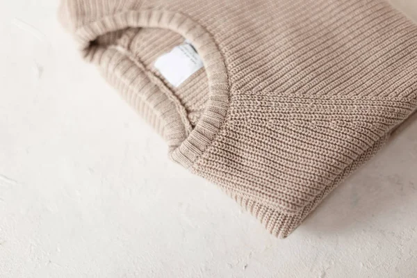 Men's fashionable beige knitted sweater on white background. Stylish knit menswear. New fashion collection handmade knitwear. Details of the everyday look. Close-up. — Stock Photo, Image