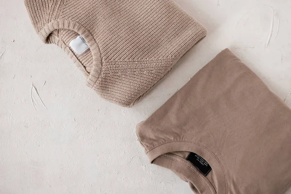 Suéter de punto cálido de moda y un cárdigan de algodón elegante beige sobre un fondo blanco. Nueva colección de ropa de hombre casual de moda. Detalles del aspecto cotidiano. Primer plano. Vista desde arriba . — Foto de Stock