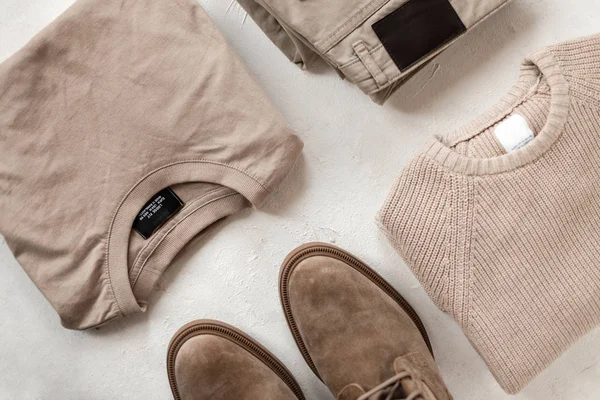 Classic vintage cotton dress shirt with a knit woolen sweater with fashion boots with trendy trousers on the table. Stylish new spring collection of men's clothing and modern shoes. Top view. Close-up — 스톡 사진