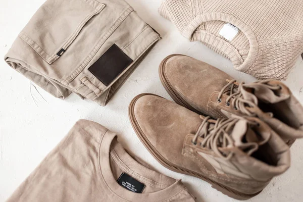 Uppsättning herrkläder och skor i beige färger på bordet. Fashionabla herrkläder vår-höst. Detaljer trendiga casual look herrkläder. Närbild. — Stockfoto