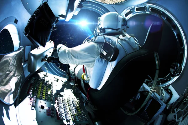 Homem do espaço sentado em uma nave espacial no espaço com um planeta. Astronauta viaja no espaço — Fotografia de Stock