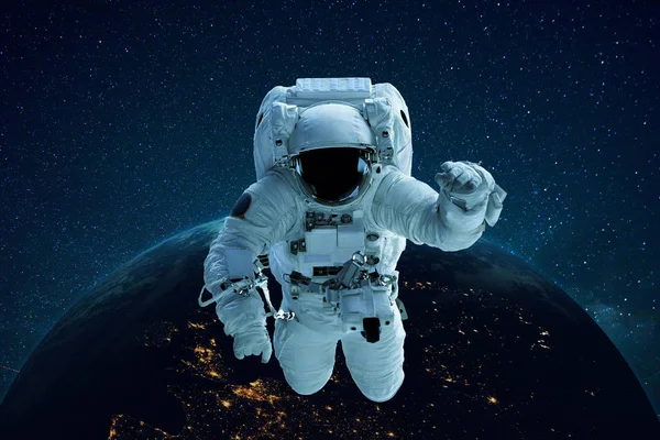Astronauta nello spazio sullo sfondo del pianeta Terra. L'Uomo Spaziale levita. Concetto di viaggio — Foto Stock