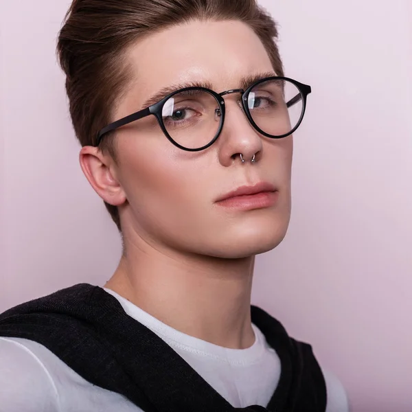 ヴィンテージの壁の近くにヘアスタイルの白いファッショナブルなTシャツの眼鏡で魅力的な若いヒップスター男性の肖像画 ピンクの背景にアメリカ人の男の顔を閉じます — ストック写真