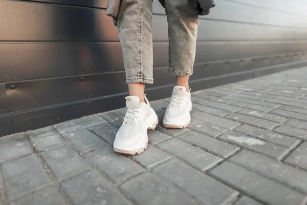 Close Van Vrouwelijke Benen Stijlvolle Leren Sneakers Trendy Jeans Straat — Stockfoto