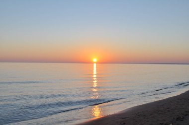 Güzel gün batımı. Sağ kıyıda, sol tarafta sonsuz genişlikte su var.