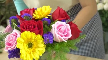 Çiçekçi kadının cam vazoda güzel çiçekler düzenlediği çekimini kapatın