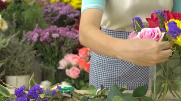 Dolly tiro de florista mulher cortando e arranjando flores em um vaso de vidro — Vídeo de Stock