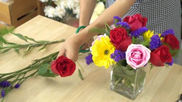 Квіткова жінка ріже квіти і влаштовує красиві квіти у скляній вазі — стокове відео