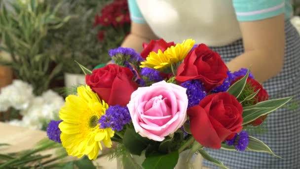 Florista mulher cortando flores e arranjando belas flores em um vaso de vidro — Vídeo de Stock