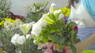 Çiçekçi kadın beyaz çiçeklerle güzel bir buket düzenlenmesi