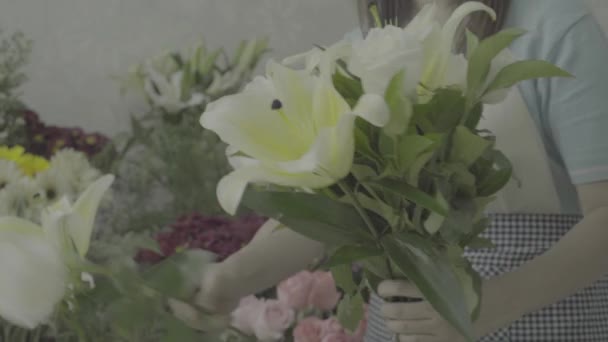 Florista mujer arreglando un hermoso ramo con flores blancas, tono sin graduar — Vídeos de Stock