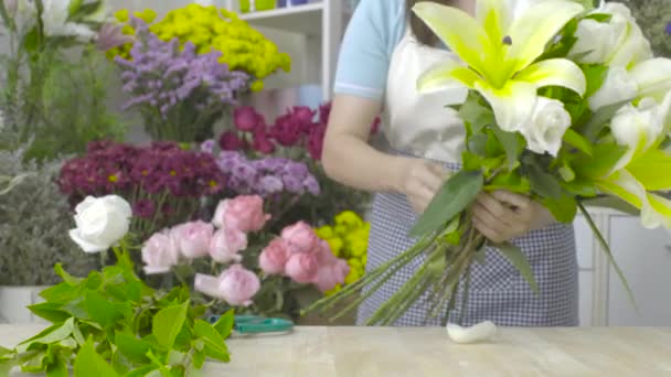 白い花で美しい花束を並べ、花屋の女性のドリーショット — ストック動画