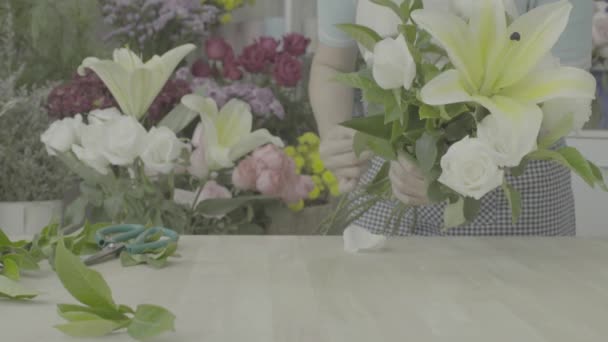 Dolly tiro de florista mulher organizando um belo buquê, tom não graduado — Vídeo de Stock