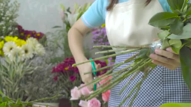 Цветочница обрезает стебли красивого букета ножницами — стоковое видео