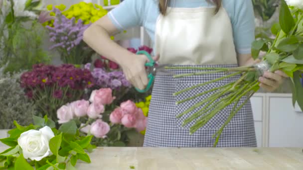 Dolly shot van bloemist vrouw trimmen stengels van mooie witte bloemen — Stockvideo